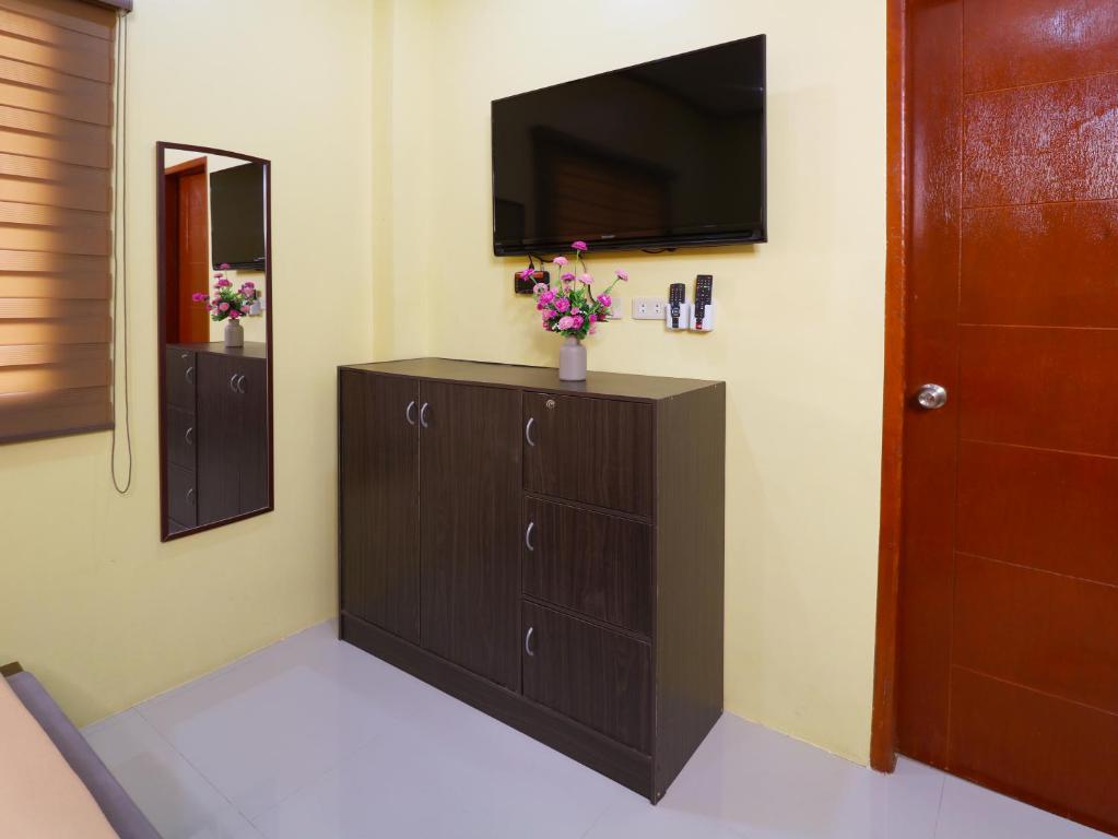 a room with a dresser with a tv on a wall at Leonida's Exclusive Resort in Talisay