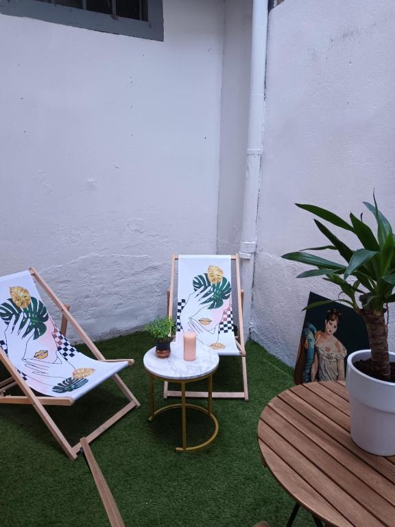 une terrasse avec 2 chaises, une table et une plante en pot dans l'établissement Chez Juliette au cœur du Vieux-Lyon, à Lyon