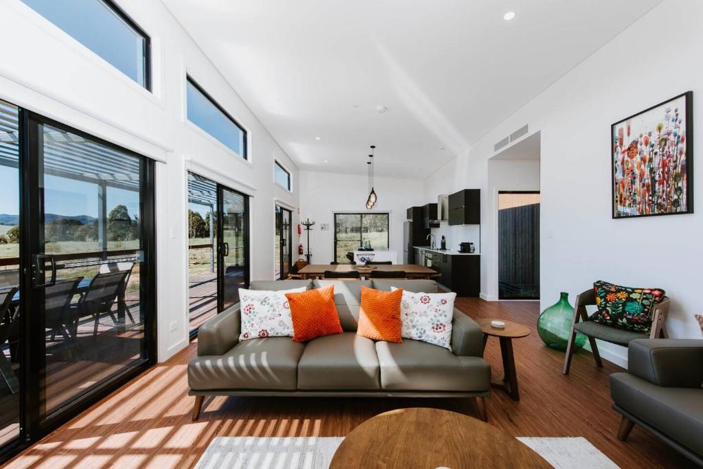 a living room with a couch and a table at Frantoio Cottage - Serene Horizons, Stylish Comforts in McDonalds Creek