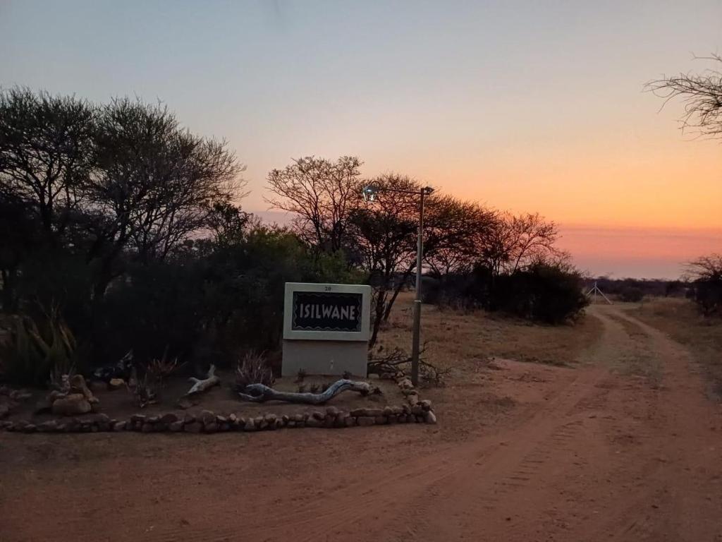 a sign sitting on the side of a dirt road at Isilwane Bush Camp in Dinokeng Game Reserve