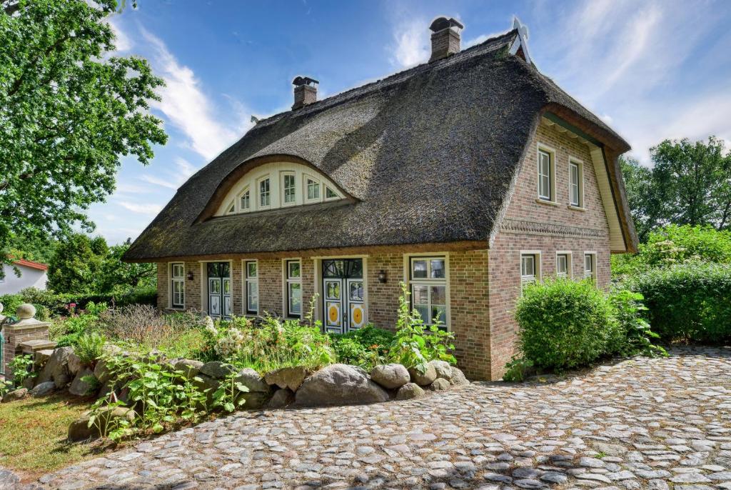 ein Backsteinhaus mit Strohdach in der Unterkunft Kapitäns Hus Ferienhaus Avantgarde in Putbus