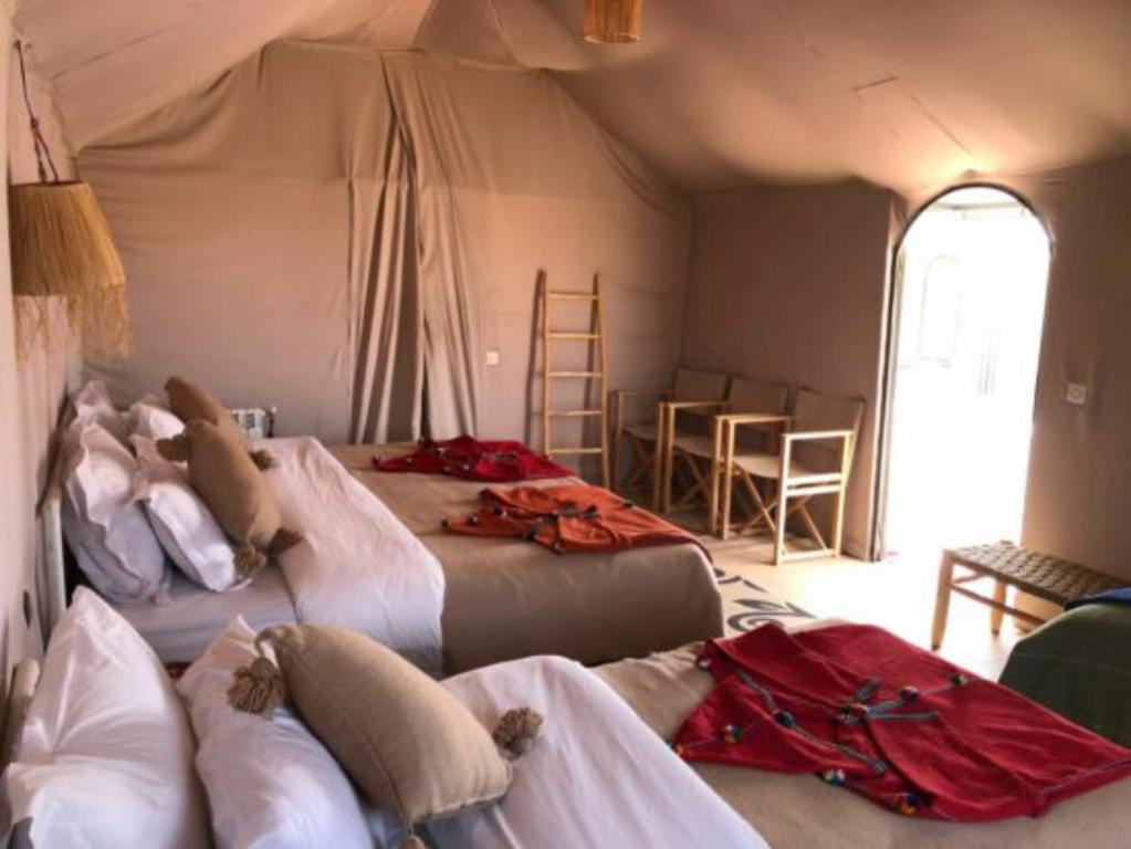 a room with two beds in a tent at Merzouga Desert Campsite &Activities in Merzouga