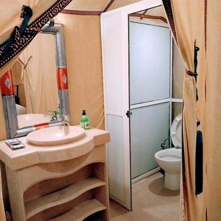 a bathroom with a sink and a toilet at Merzouga Desert Campsite &Activities in Merzouga