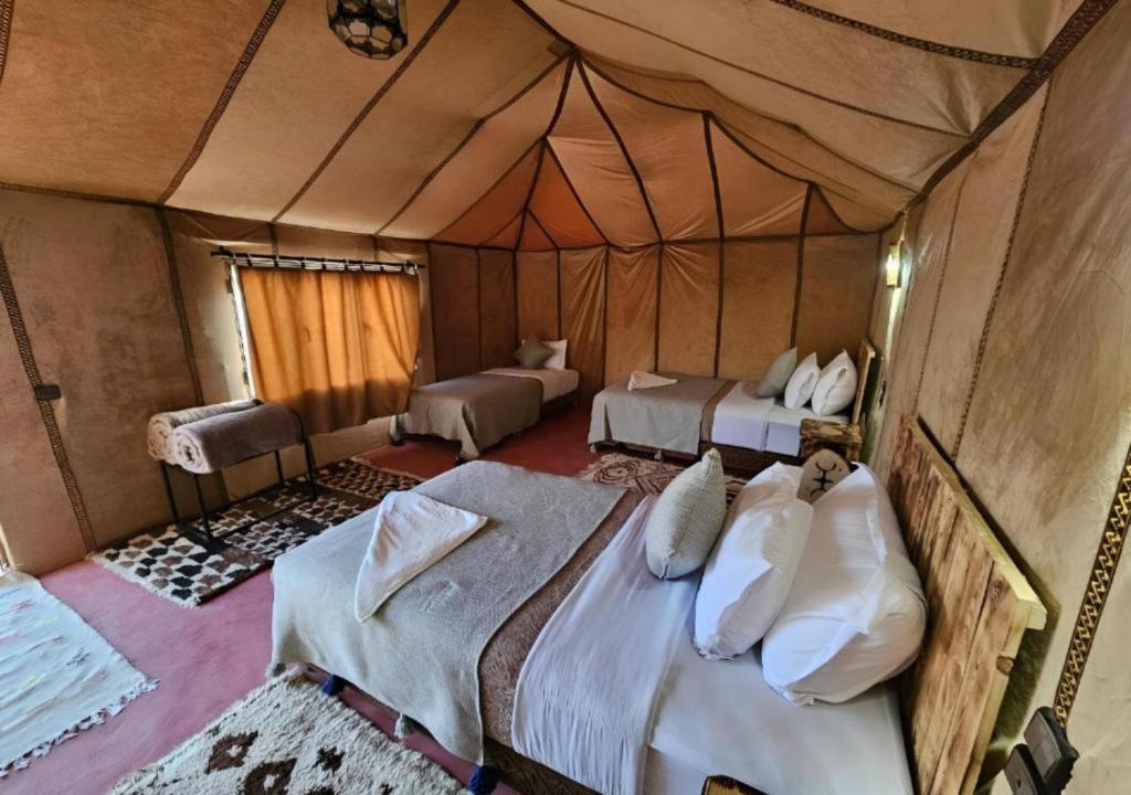 a bedroom with two beds in a tent at Merzouga Desert Campsite &Activities in Merzouga