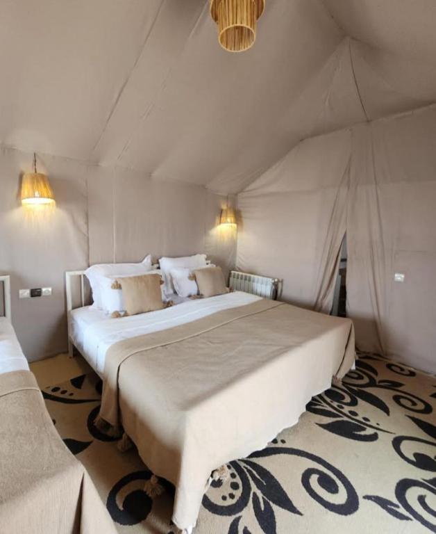 a bedroom with a large bed in a tent at Merzouga Desert Campsite &Activities in Merzouga