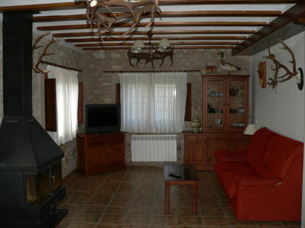 sala de estar con sofá rojo y TV en La Insula de Castilnuevo, en Castilnuevo