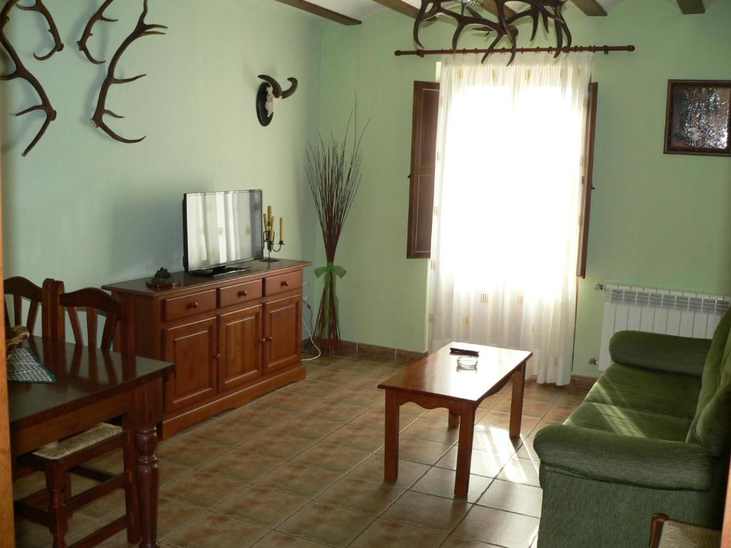 sala de estar con sofá, TV y mesa en La Insula de Castilnuevo, en Castilnuevo
