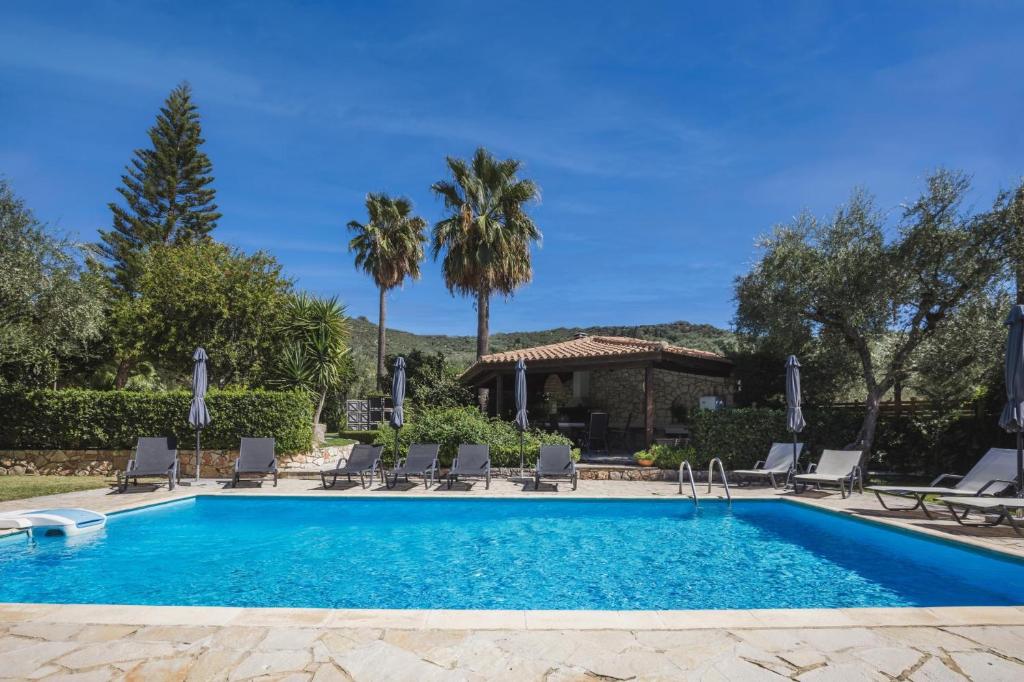a swimming pool with chairs and a house at Villa Lilly with private pool in Kipseli