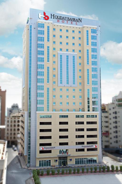 a large building with a hotel sign on top of it at Holiday Bahrain Hotel in Manama