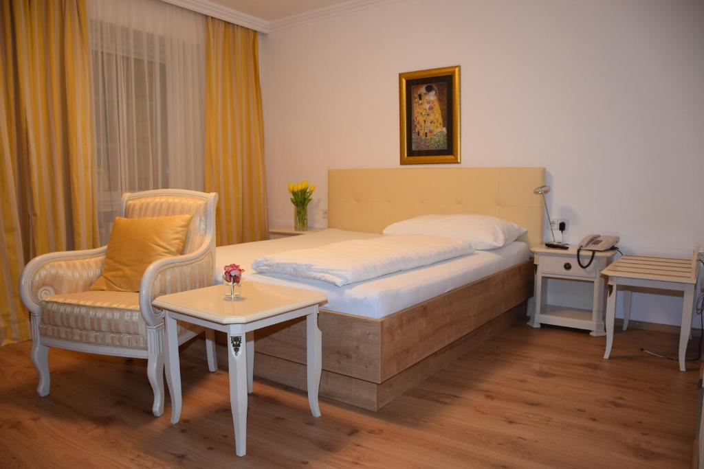 una camera con letto, tavolo e sedia di Appartement-Hotel GH Zum Goldenen Schiff a Enns