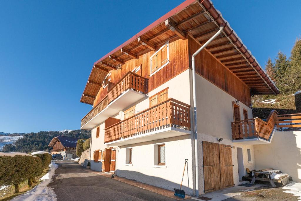 ein Haus mit Holzbalkonen an der Seite in der Unterkunft Le Rouge-Gorge in Cordon