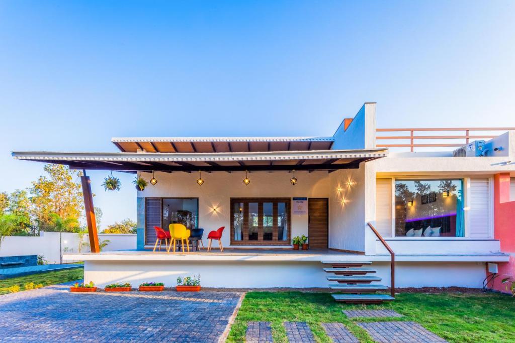 a house with a view of the backyard at SaffronStays Blue Jasmine in Nashik