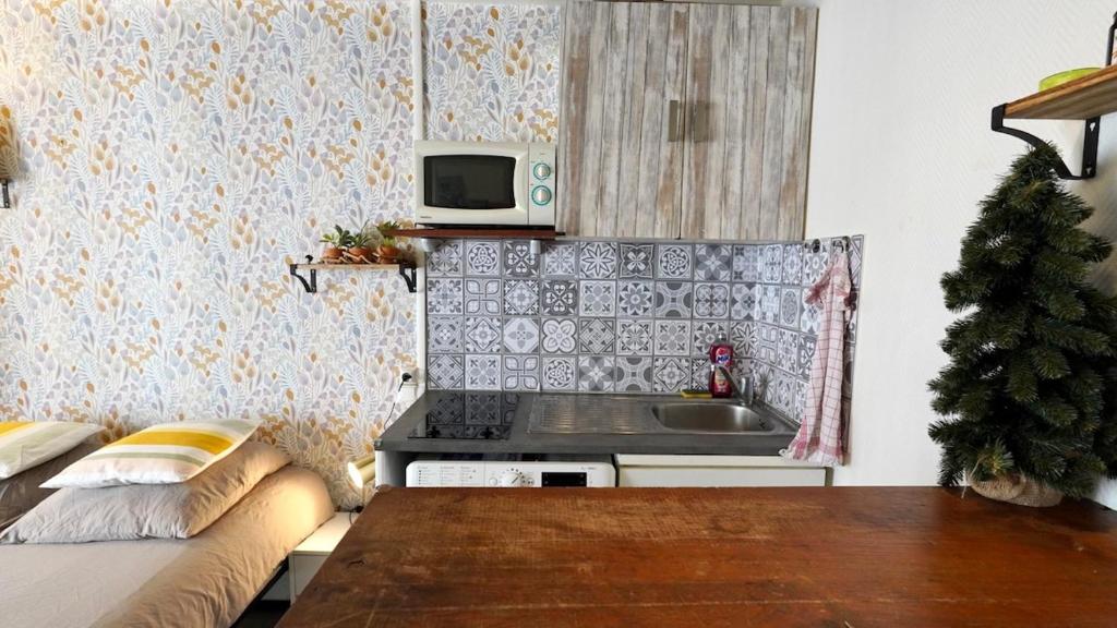 une petite cuisine avec un canapé et un évier dans l'établissement 04 Grand studio near République, à Paris