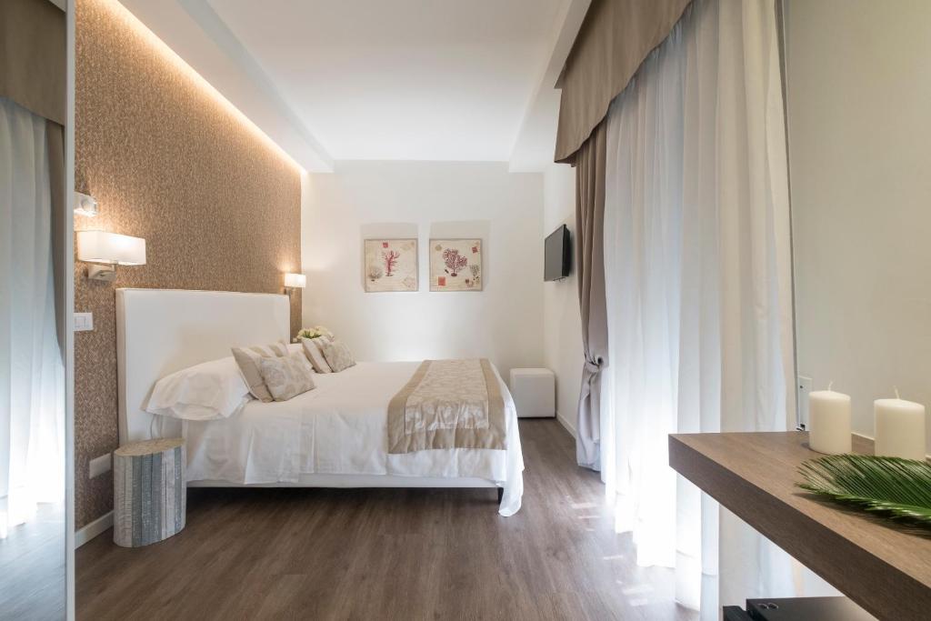 sypialnia z białym łóżkiem i białymi zasłonami w obiekcie Hotel Mon Cheri w mieście Riccione