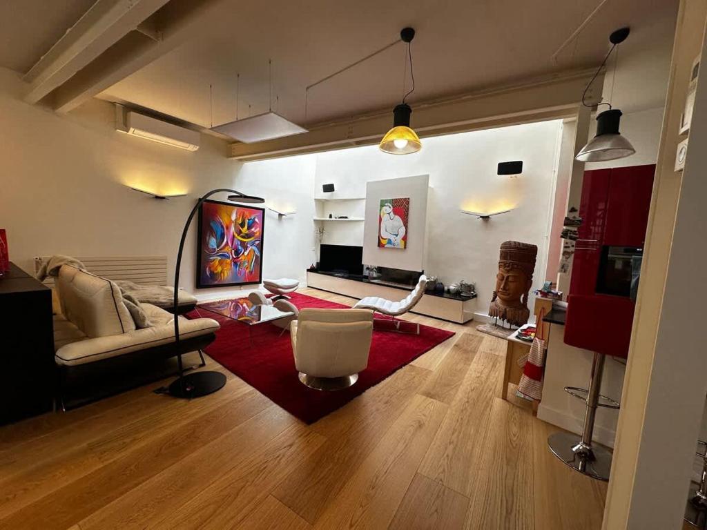 un salon avec un canapé et un tapis rouge dans l'établissement Family Designer House in The Heart of Montparnasse, à Paris