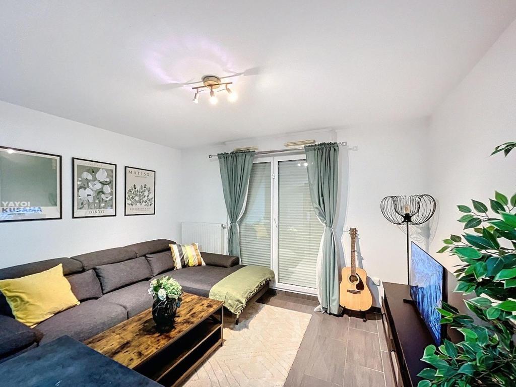 un salon avec un canapé et une guitare dans l'établissement 2 Bedrooms, near Paris, family friendly, metro RER, à Rosny-sous-Bois