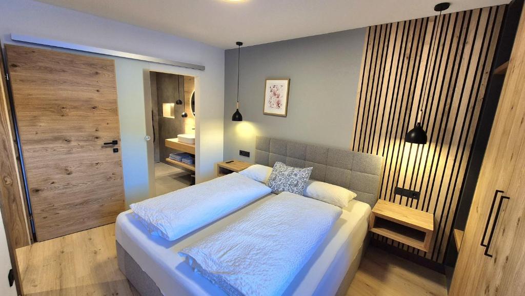 a bedroom with a large bed and a bathroom at Apartment Sunplatzl in Forstau