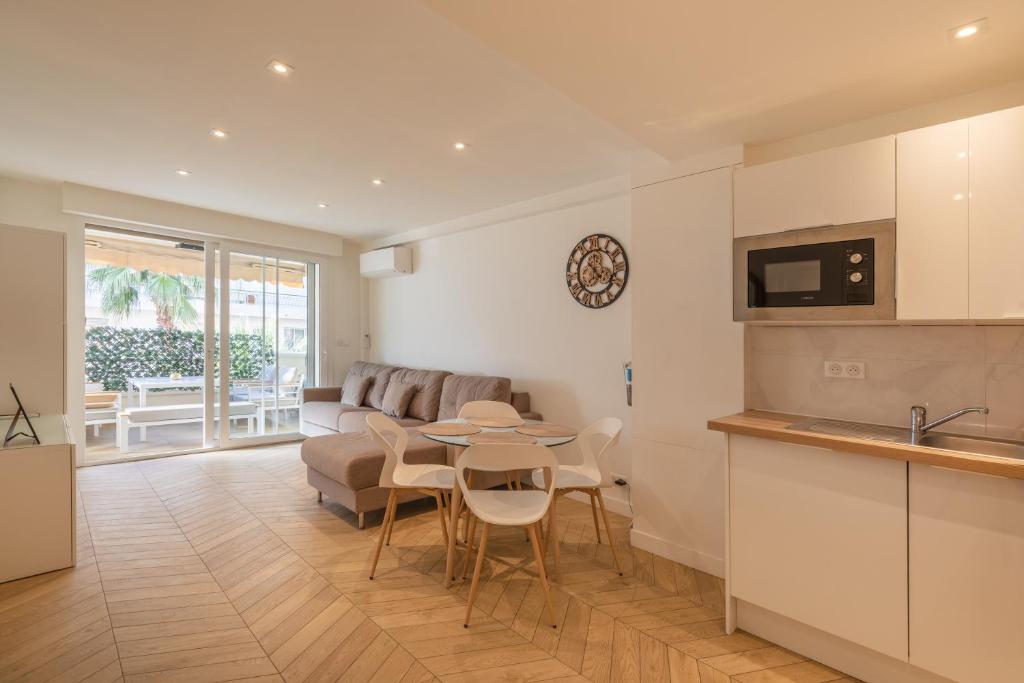une cuisine et un salon avec une table et un canapé dans l'établissement LE CALIFORNIA 200m des plages chic luxe et cosy 2 à 4 personnes, à Antibes