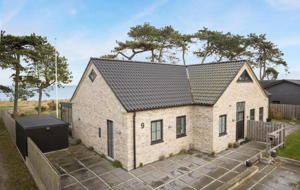 a white brick house with a black roof at Nice Home In Odder With House Sea View in Odder