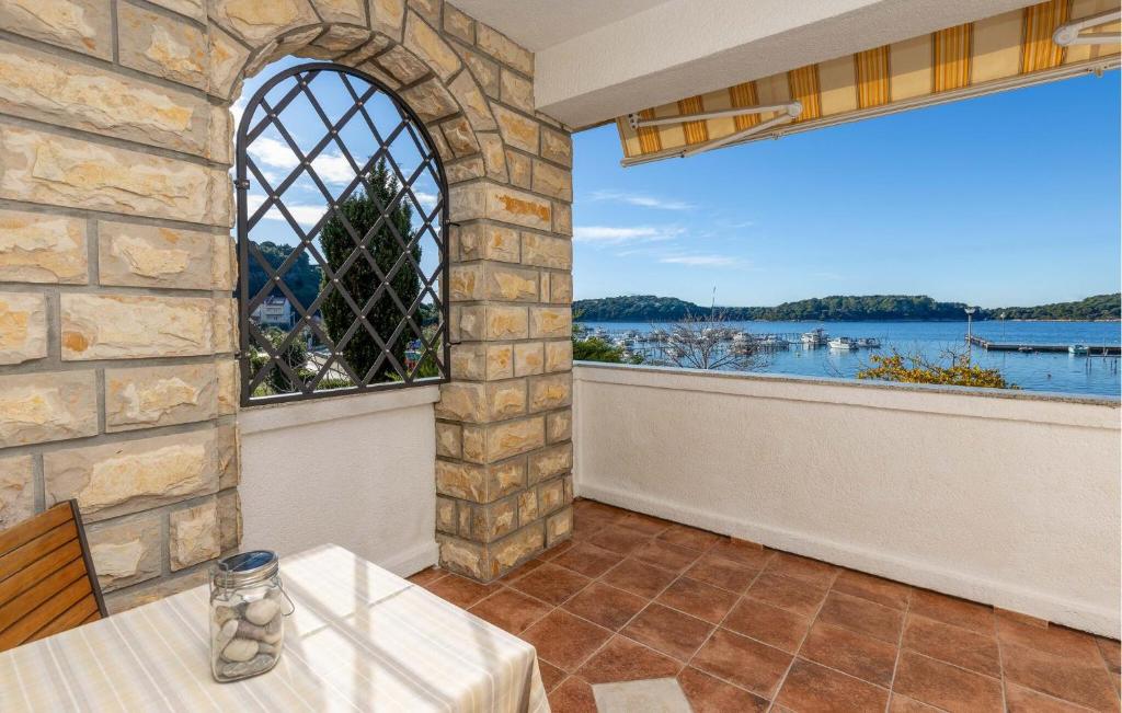 d'une terrasse avec une table et une vue sur l'eau. dans l'établissement Nice Apartment In Palit With Wifi, à Palit