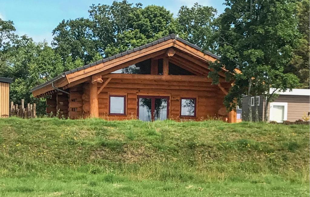 a log cabin on a hill with grass and trees at 3 Bedroom Lovely Home In Den Oever in Den Oever