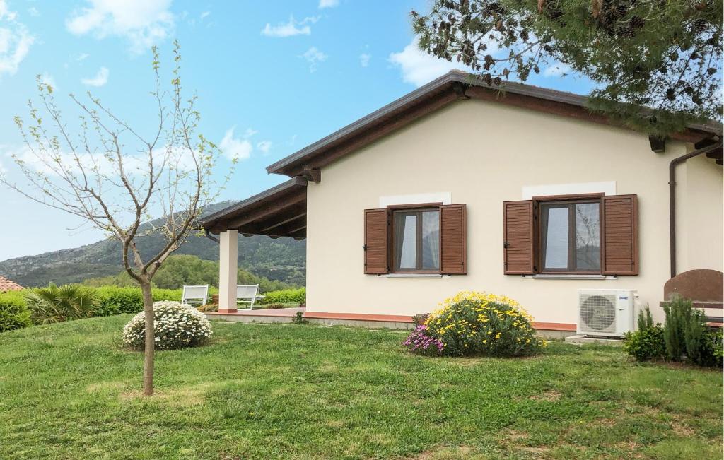 a white house with brown windows and a green yard at Lovely Home In San Giovanni A Piro in San Giovanni a Piro