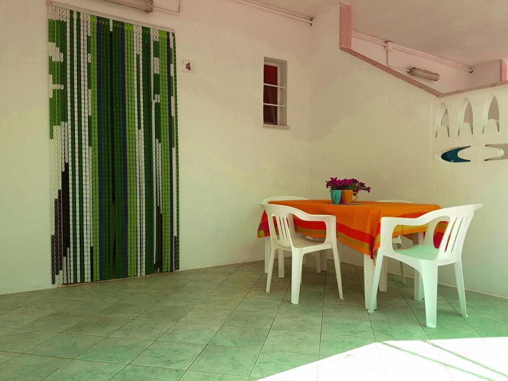 Un comedor con una mesa y dos sillas. en Casette sulla spiaggia di Punta Prosciutto, en Punta Prosciutto