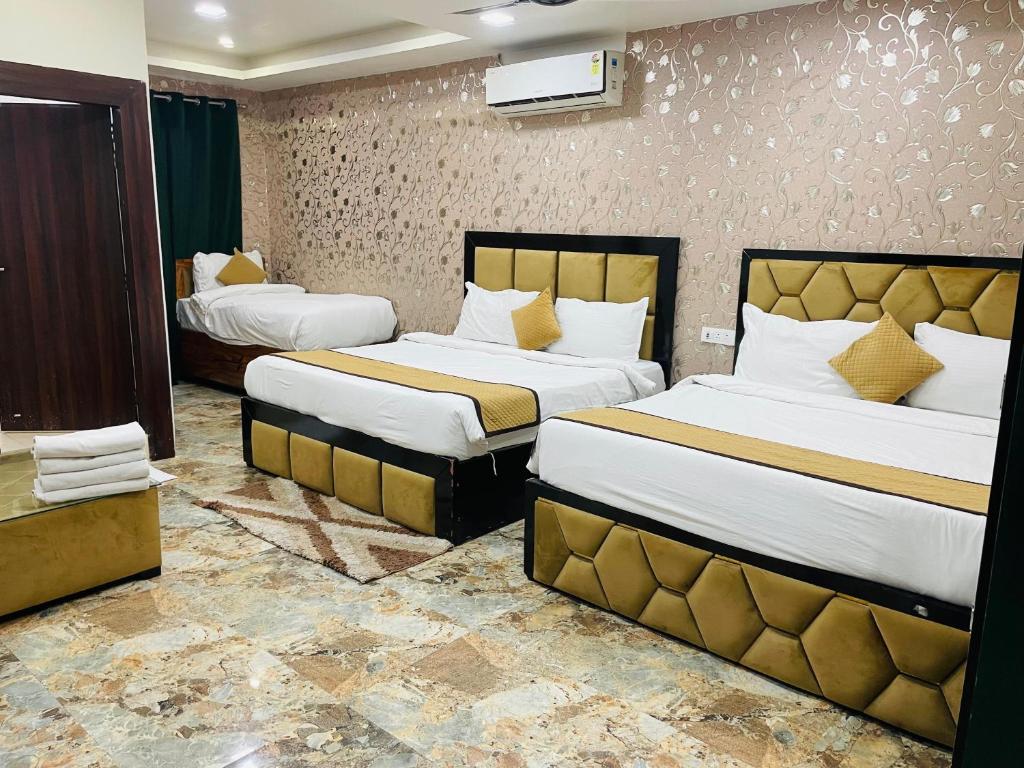 a hotel room with two beds in a room at The Tulsi Garden Vrindavan near Omaxe city in Vrindāvan