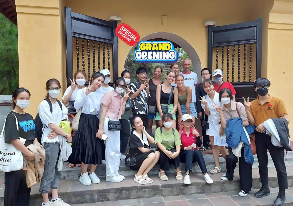 un grupo de personas usando máscaras posando para una foto en Hue Central Backpacker Hostel, en Hue