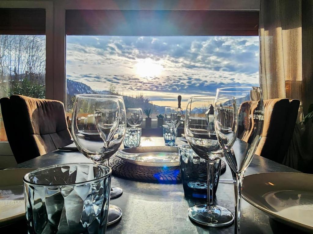 - une table avec des verres à vin et une vue dans l'établissement L'Ecrin de Megève, à Megève