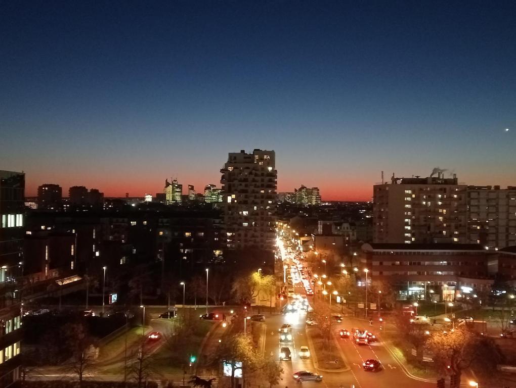 une vue sur la ville la nuit avec des voitures dans une rue dans l'établissement Dolce Sarah, à Asnières-sur-Seine