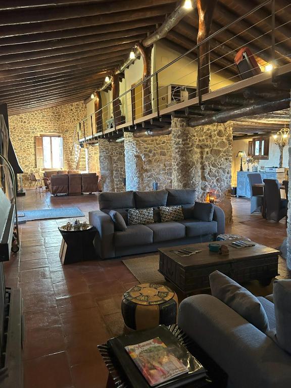 a large living room with couches and a stone wall at Finca El Corchito Aracena in Aracena