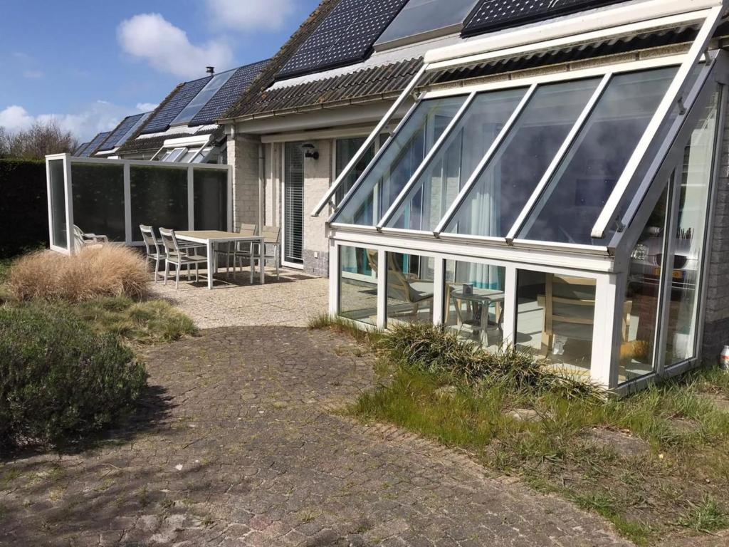 an extension to a house with solar panels on the roof at Comfortable 6-person holiday home in Sint Maartenszee