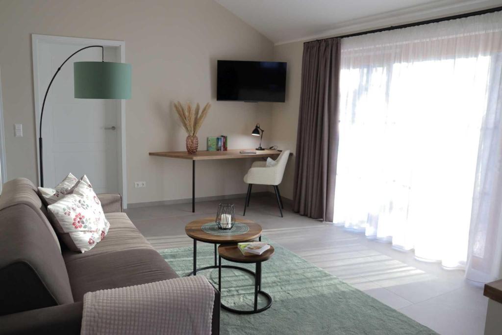 ein Wohnzimmer mit Sofa und Tisch in der Unterkunft Ferienwohnung Weinbergsliebe in Rümmelsheim