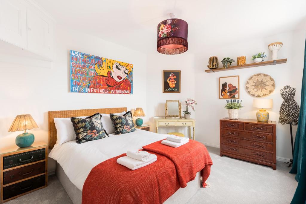 a bedroom with a bed with a red blanket at Queens Head Boutique Hotel Apartments in Gloucestershire