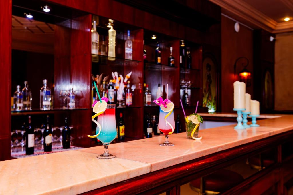 a bar with three cocktails sitting on a counter at Iris Hotel & Thalasso in Taguermess