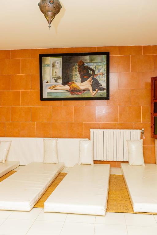 a room with three beds and a painting on the wall at Iris Hotel & Thalasso in Taguermess