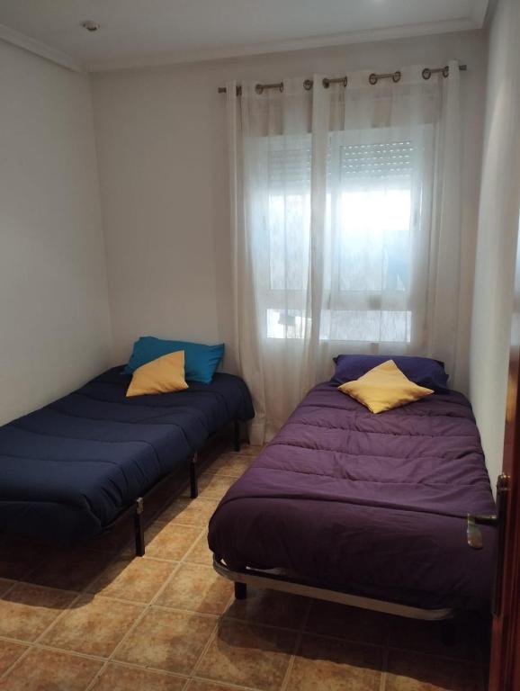 two beds sitting in a room with a window at Torrevieja Centro in Torrevieja