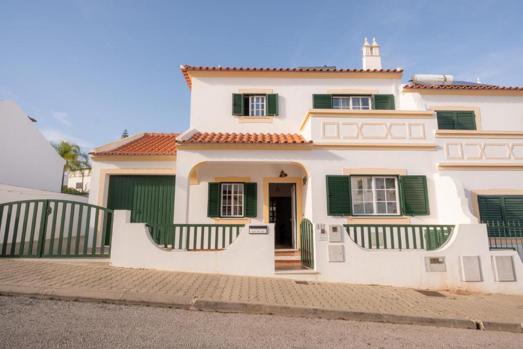 a large white house with green shutters at Altura Vacations V3, Algarve in Altura