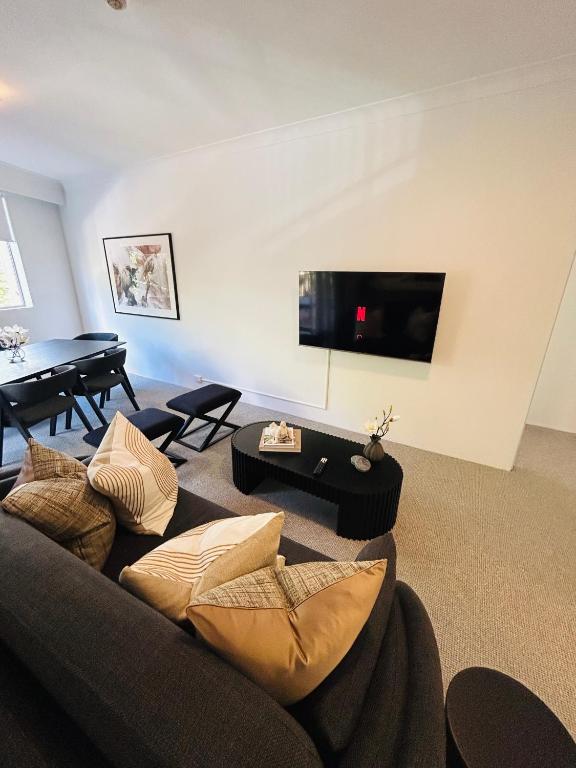 悉尼KozyGuru Camperdown Cozy 2-Bed Apt and Parking的带沙发和桌子的客厅