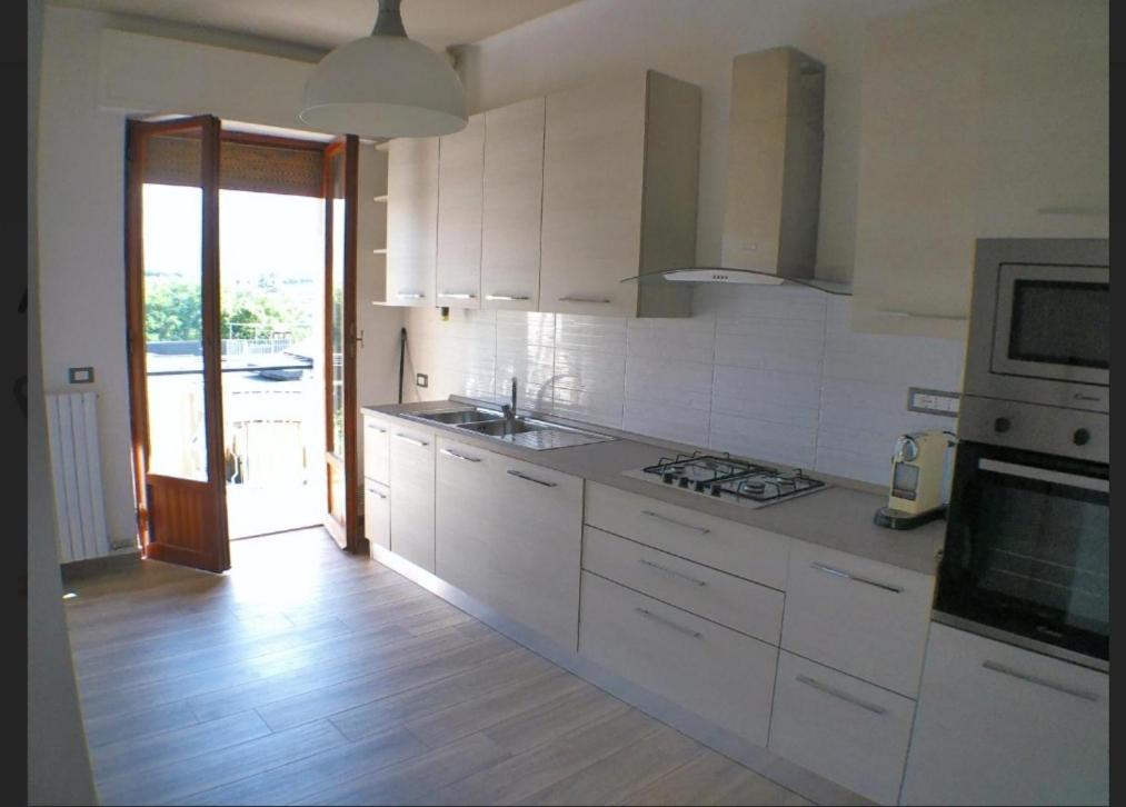 a kitchen with white cabinets and a stove top oven at Casa Serena in Carrara
