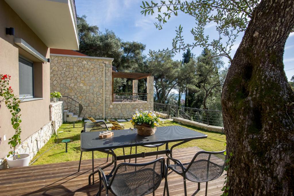 a patio with a table and chairs on a deck at Topos Villas in Parga
