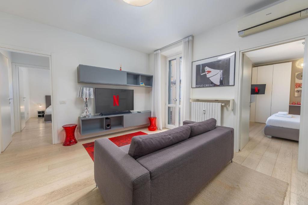 a living room with a couch and a television at Kramer House-Porta Venezia-5min to Duomo in Milan