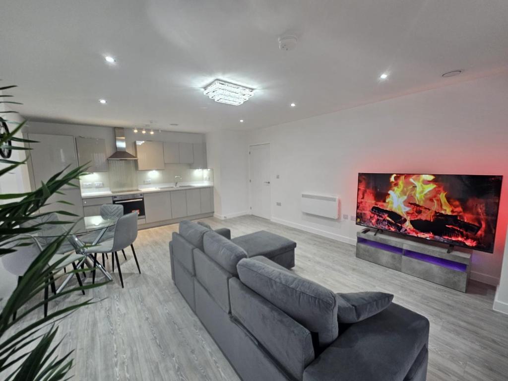 a living room with a couch and a tv on the wall at Serenity Waterfront 2 Bed Apartment in Northfleet