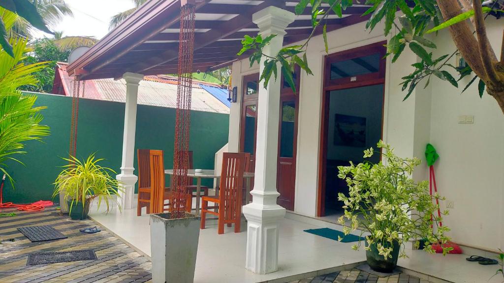 una veranda di una casa con tavolo e sedie di Beach side villa a Bentota