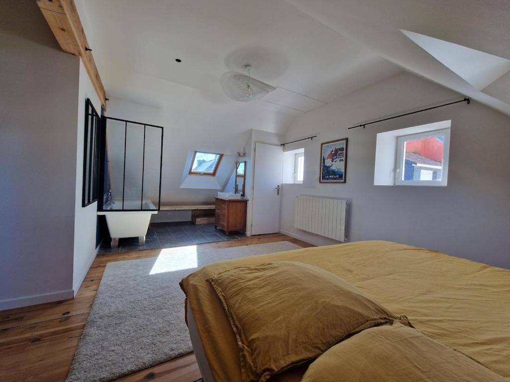 une chambre avec un grand lit et une salle de bain dans l'établissement Maison à deux pas de la mer, à Gâvres
