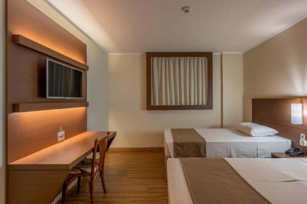 Postel nebo postele na pokoji v ubytování Hotel Caiuá Cascavel