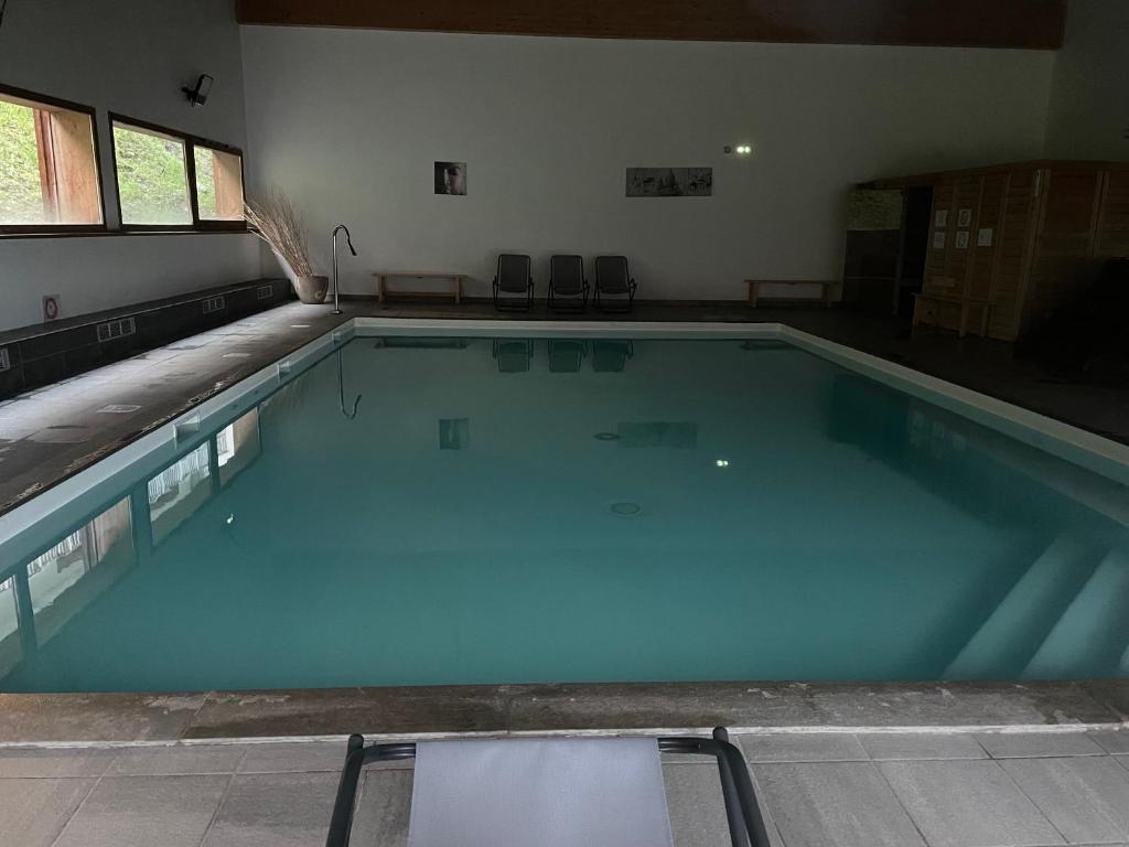- une grande piscine d'eau bleue dans une chambre dans l'établissement Les 3 vallées, à Orelle