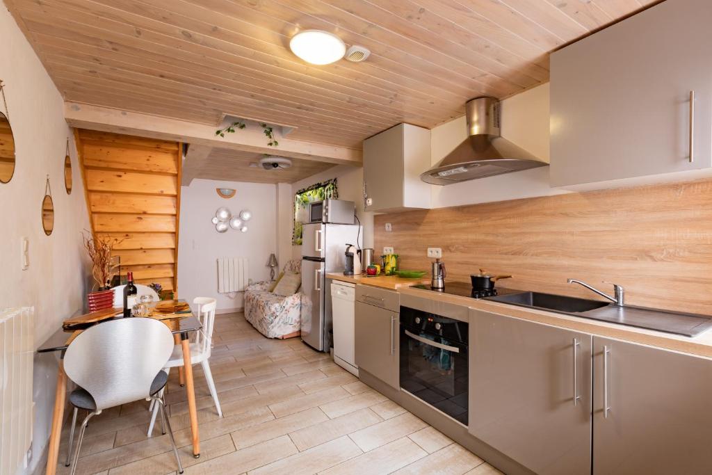 una cocina con una mesa y una encimera en L'Écrin des Bois - Au bord de l Aude, en Espéraza