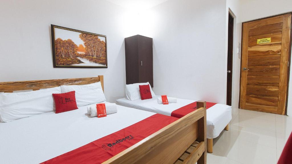 Postel nebo postele na pokoji v ubytování RedDoorz Plus @ Jollydays Hotel Nueva Ecija